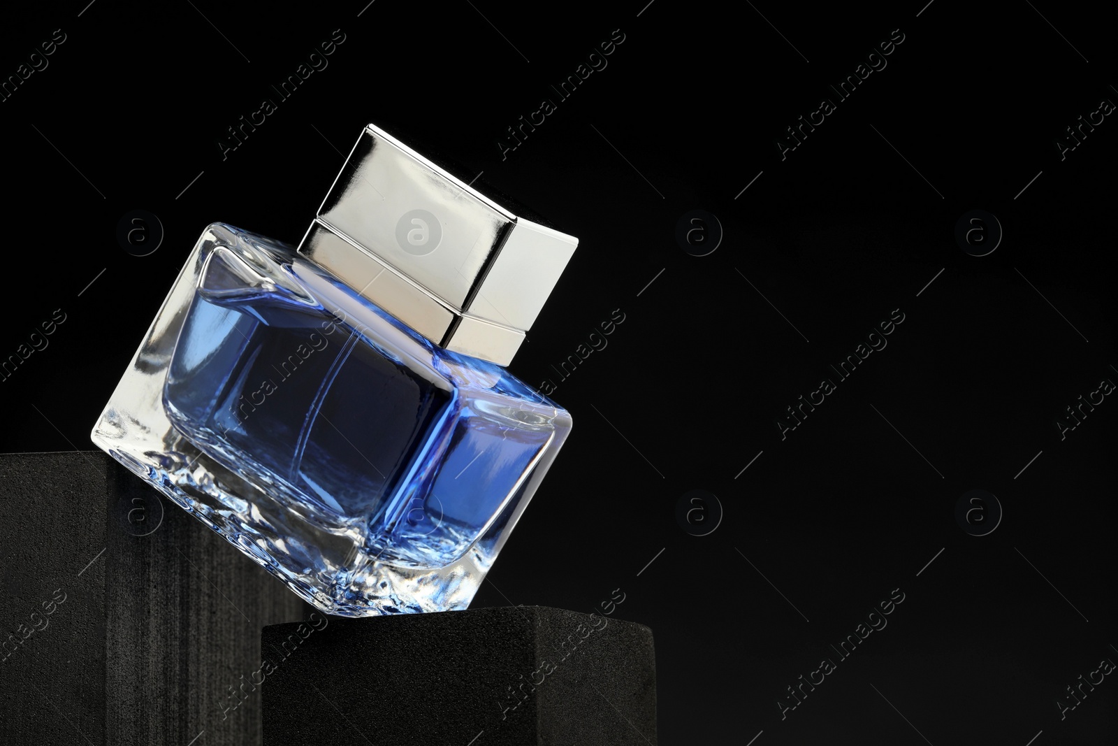 Photo of Luxury men`s perfume in bottle against dark background, space for text