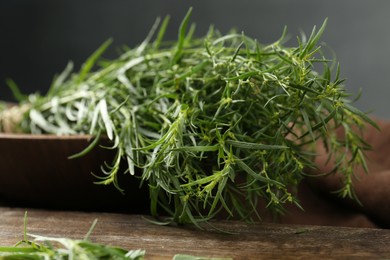 Photo of Bunch of fresh tarragon on wooden table