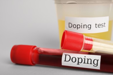 Closeup view of jar and test tubes with samples on light grey background. Doping control