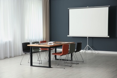 Modern meeting room interior with large table and projection screen