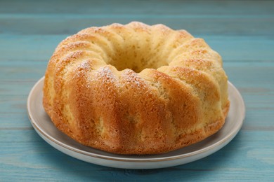 Photo of Delicious freshly baked sponge cake on light blue wooden table, closeup