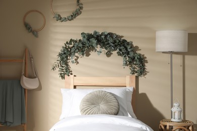 Photo of Stylish bedroom decorated with beautiful eucalyptus garland
