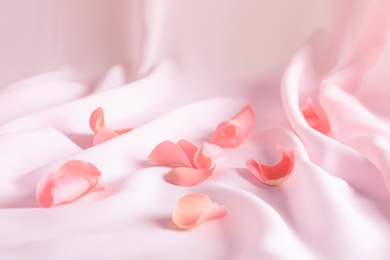 Photo of Beautiful rose petals on soft pink fabric