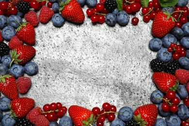 Photo of Frame of different fresh berries on grey background, top view. Space for text