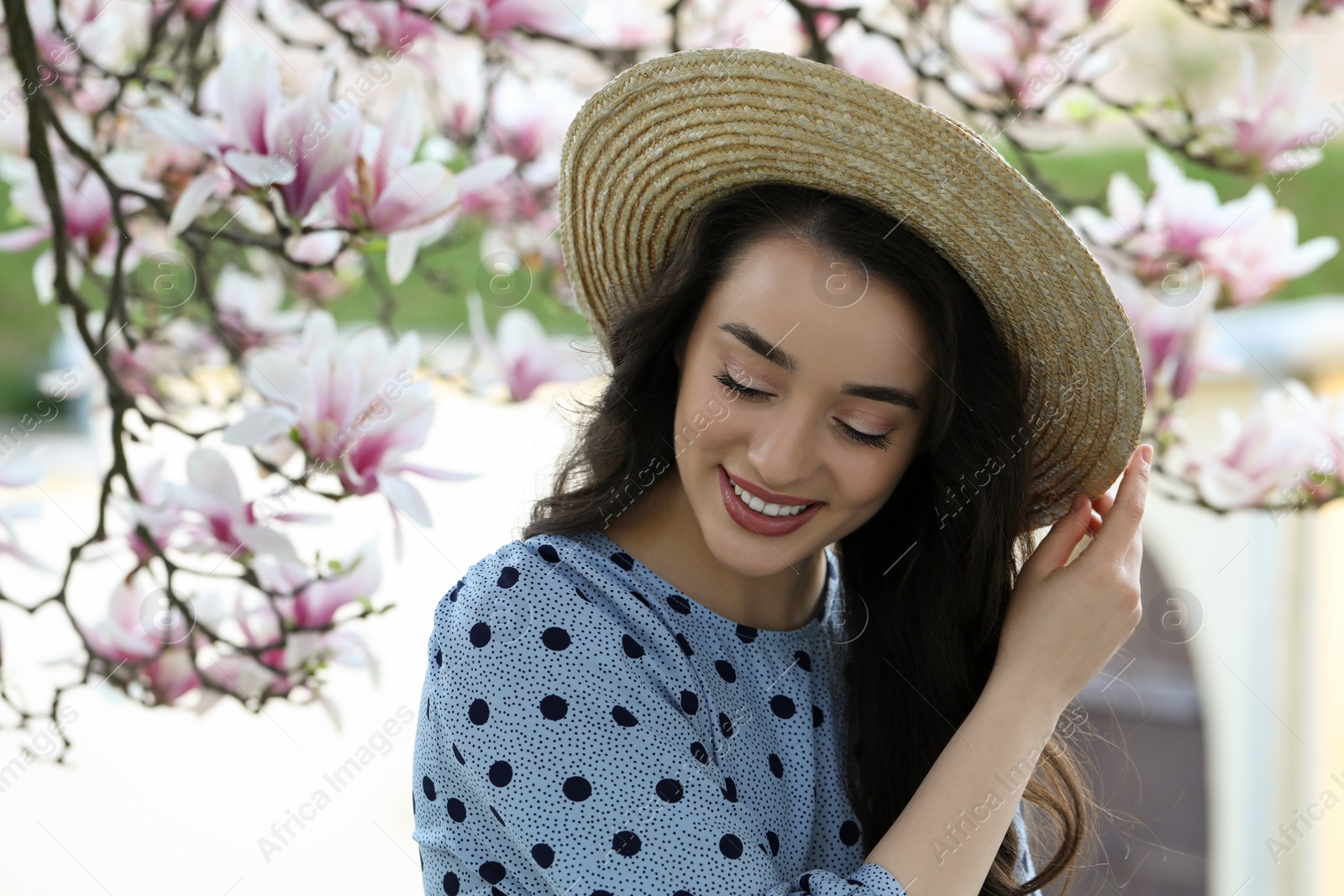 Photo of Beautiful woman near blossoming magnolia tree on spring day