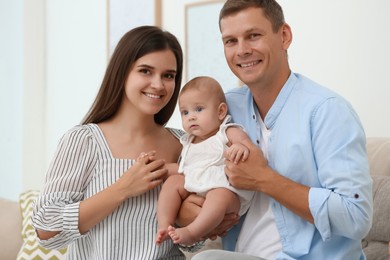 Portrait of happy family with their cute baby at home