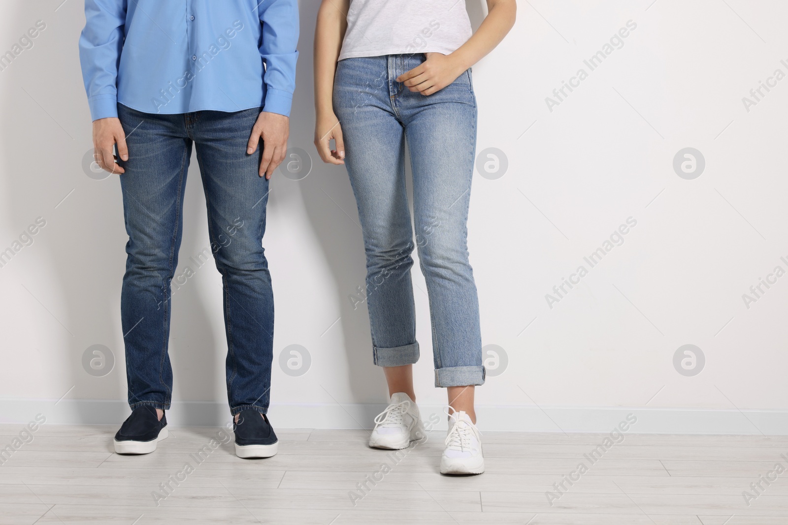 Photo of People in stylish jeans near white wall indoors, closeup