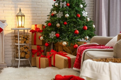 Photo of Stylish interior with beautiful Christmas tree and gift boxes