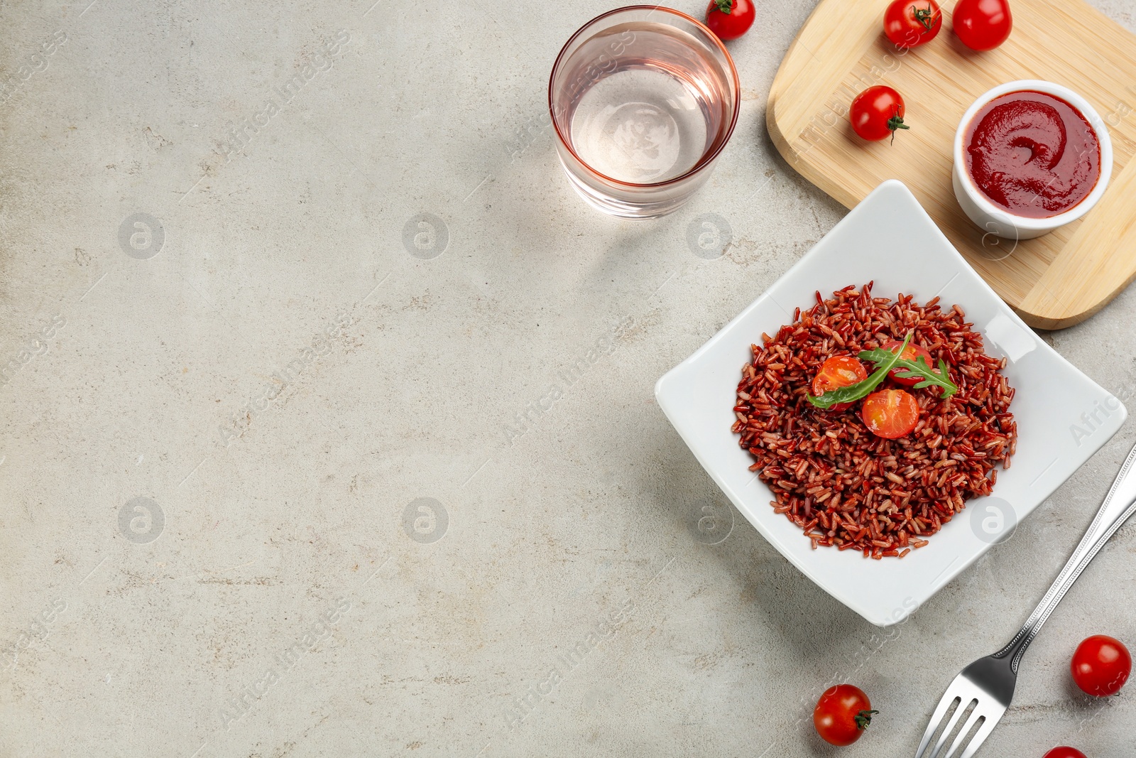 Photo of Tasty brown rice on grey table, flat lay. Space for text