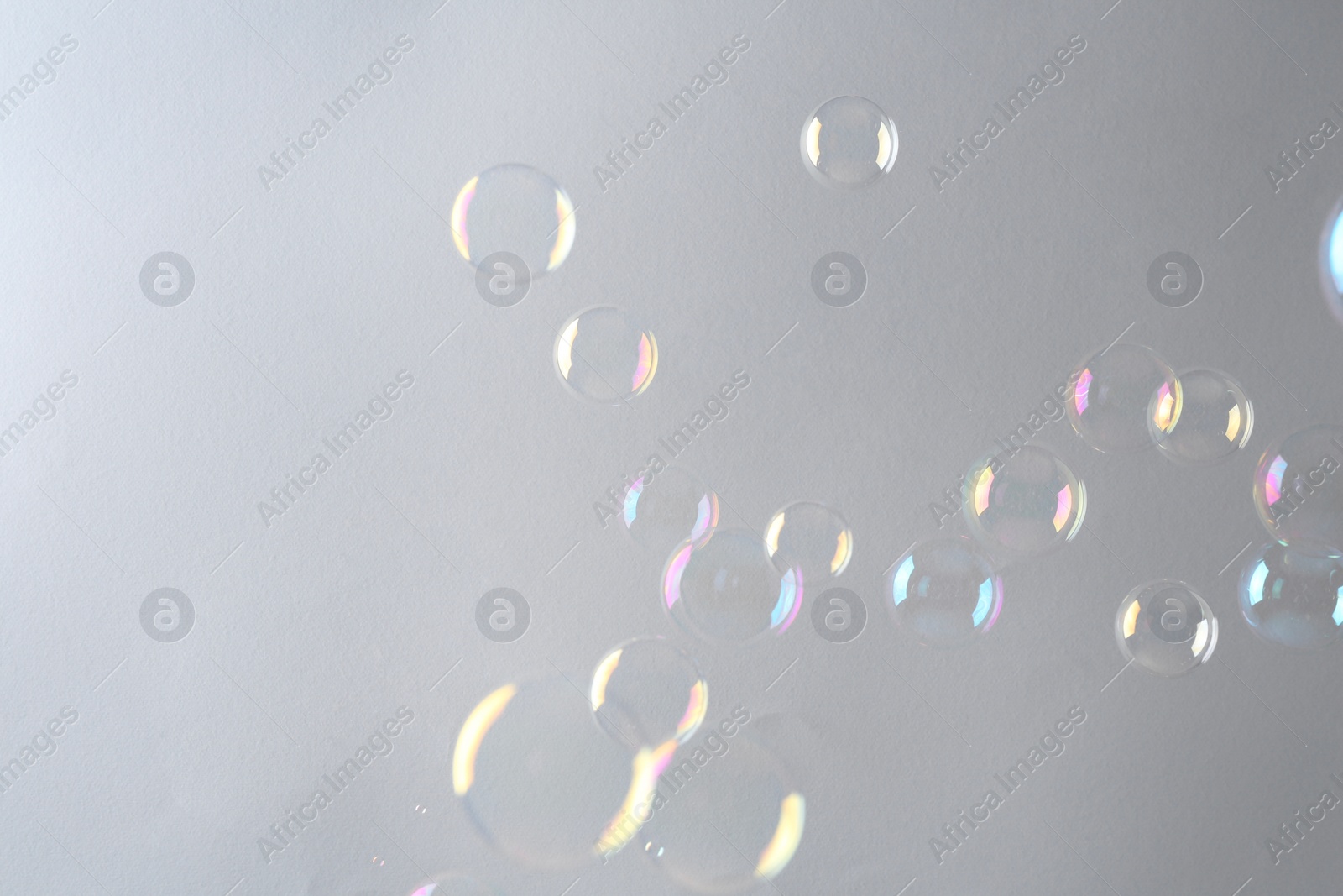 Photo of Beautiful transparent soap bubbles on gray background