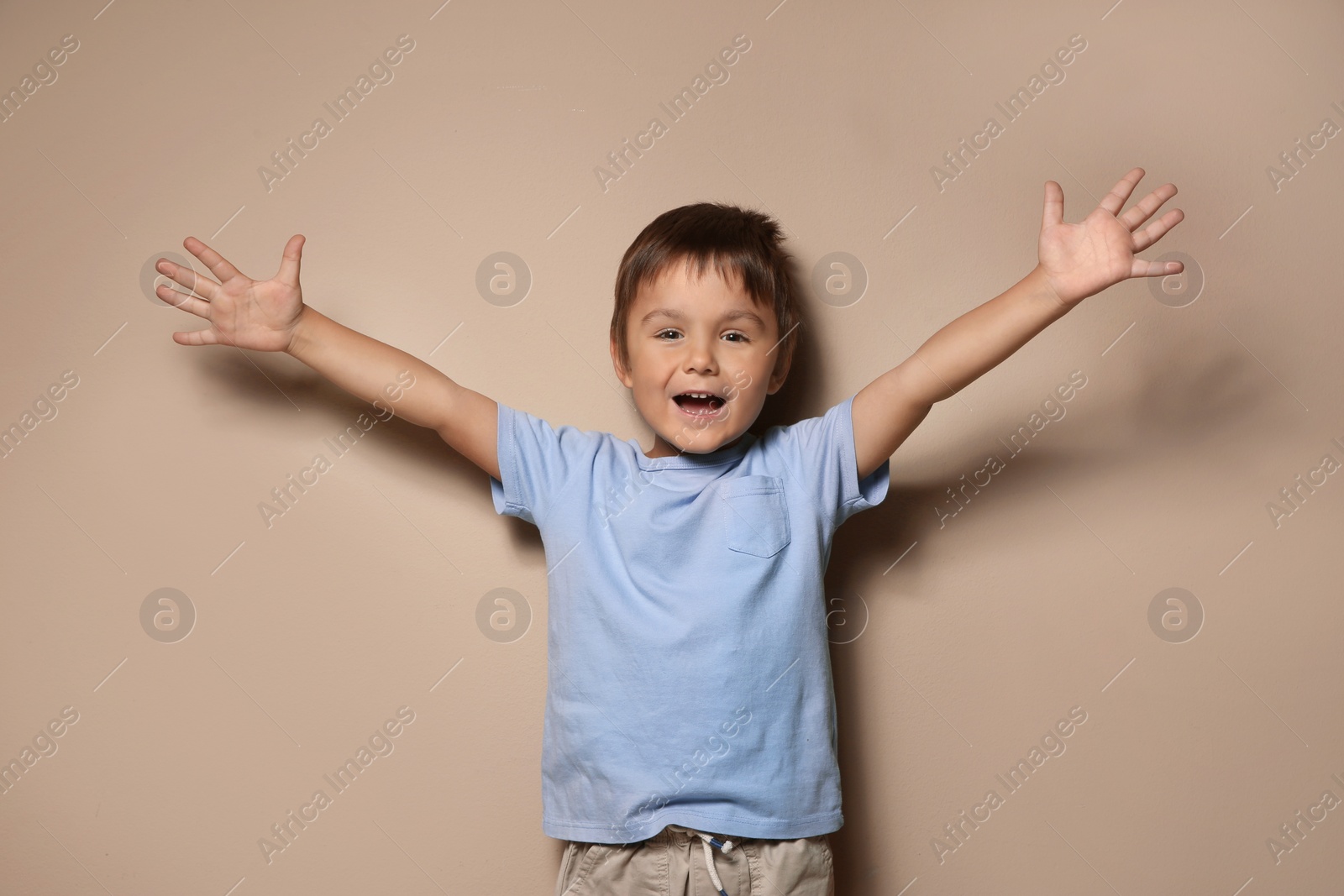 Photo of Portrait of happy little boy on beige background