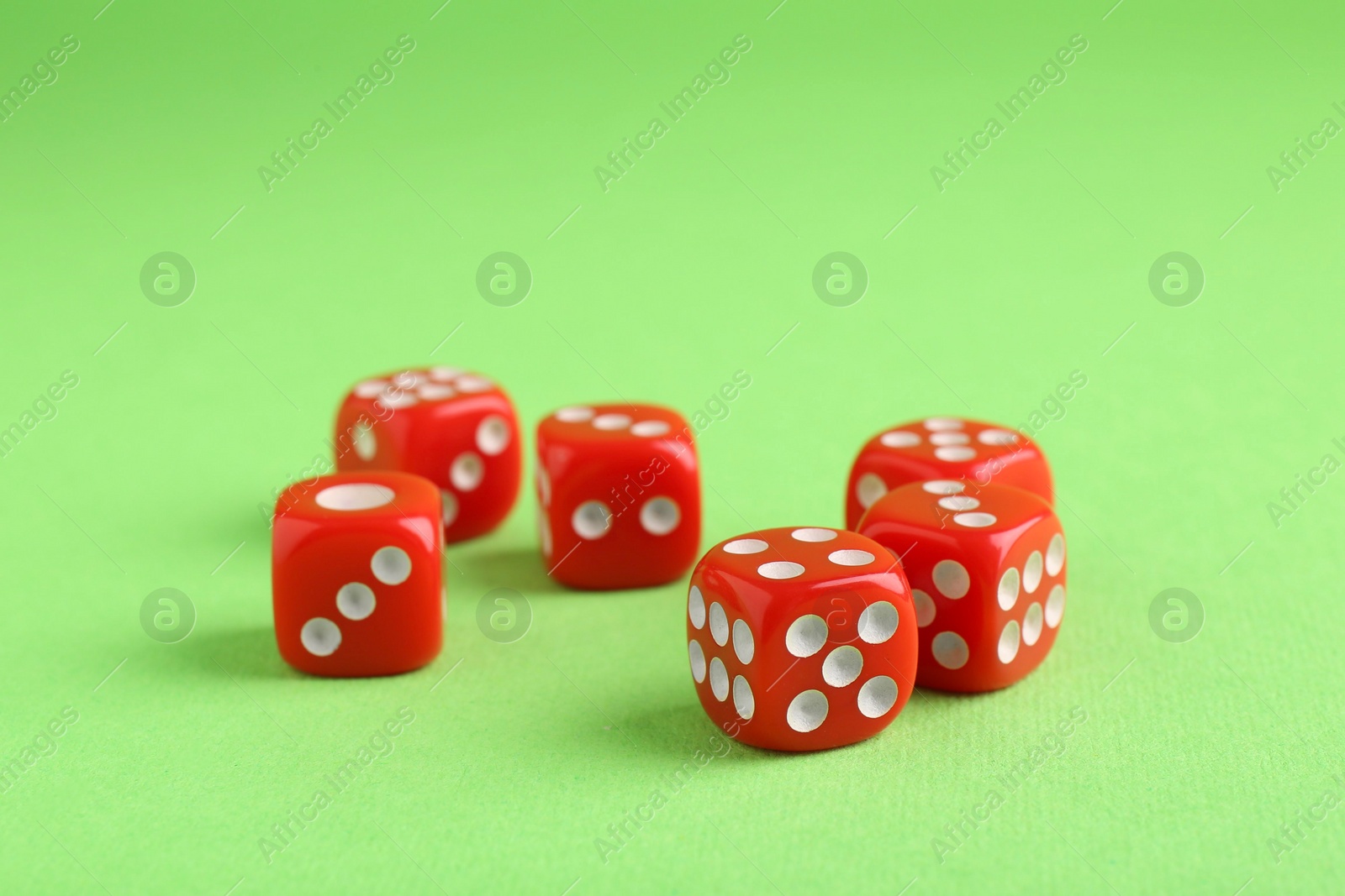 Photo of Many red game dices on green background