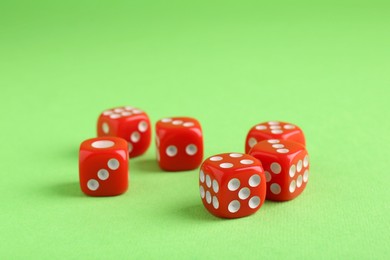 Many red game dices on green background