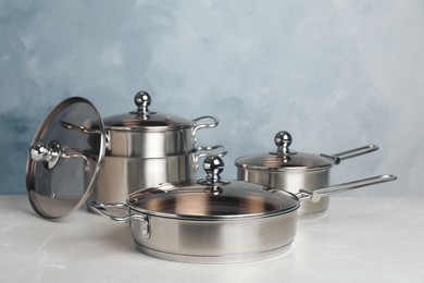 Photo of New cookware set on light grey table