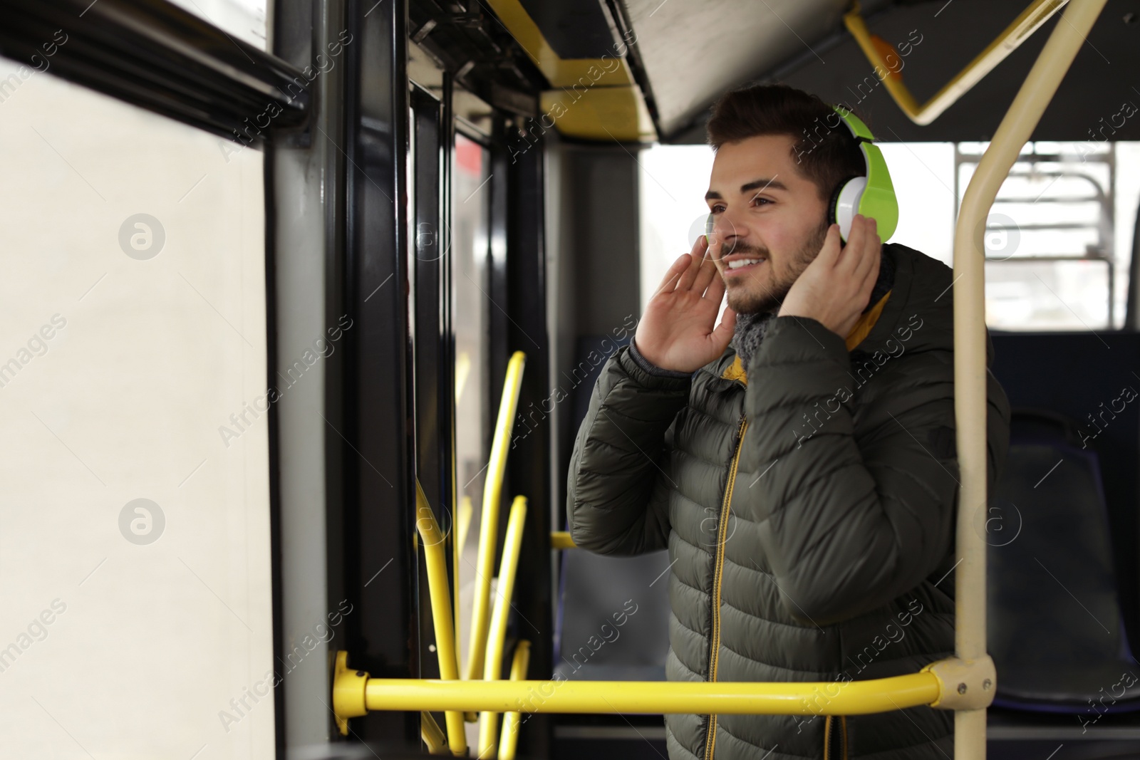 Photo of Young man listening to music with headphones in public transport