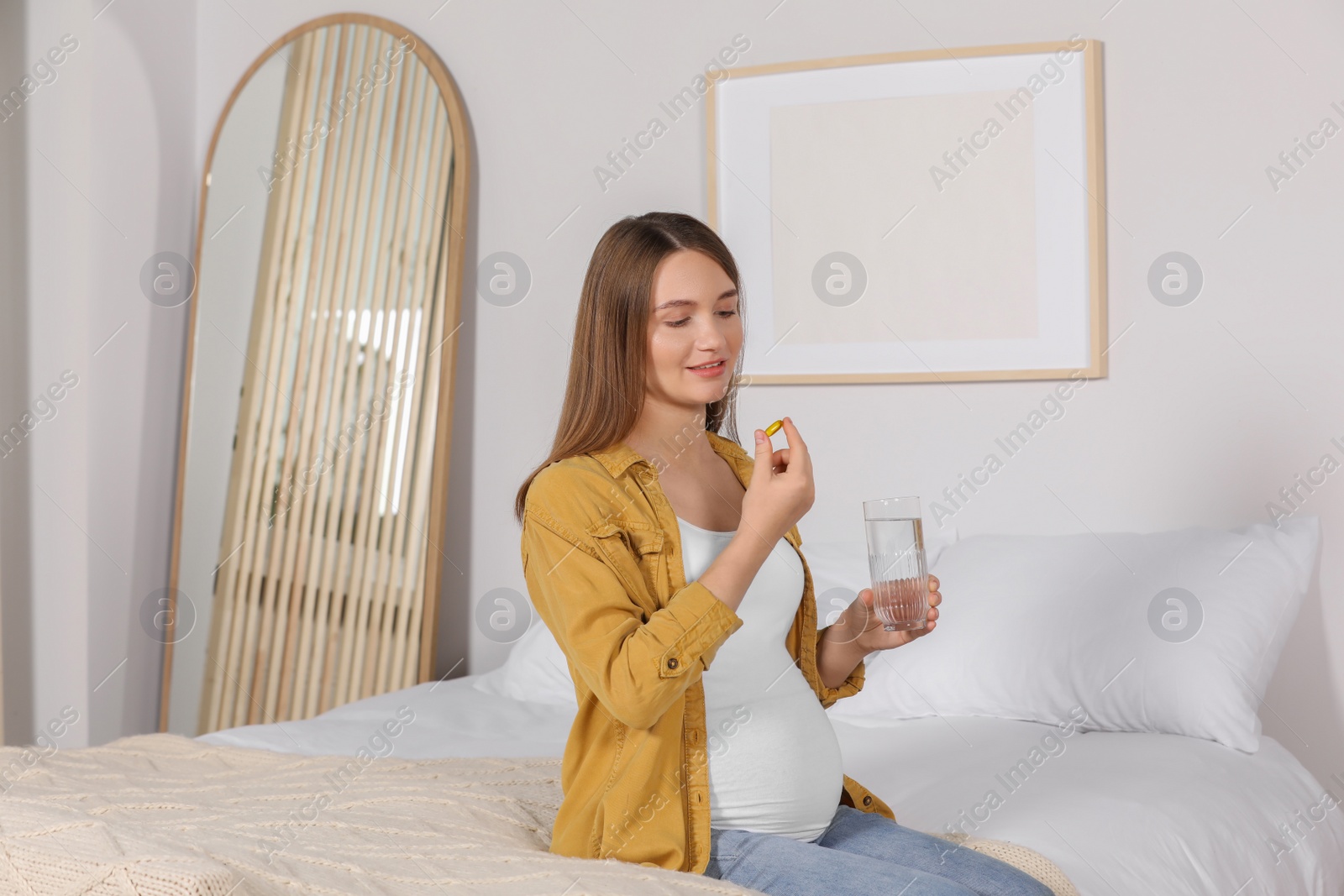 Photo of Beautiful pregnant woman taking pill at home