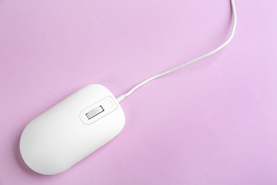 Photo of Modern wired optical mouse on lilac background, top view