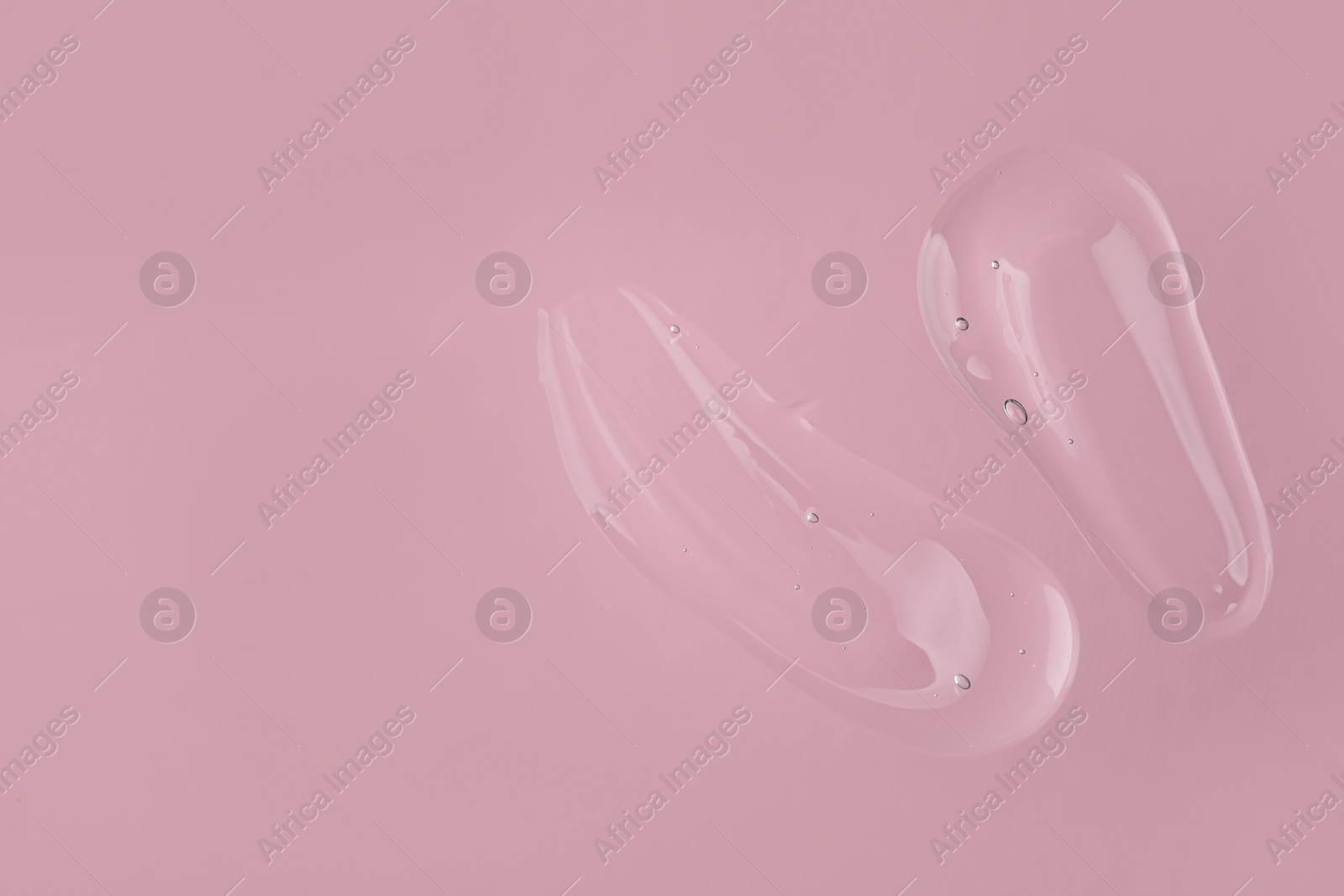 Photo of Samples of cleansing gel on pink background, top view with space for text. Cosmetic product