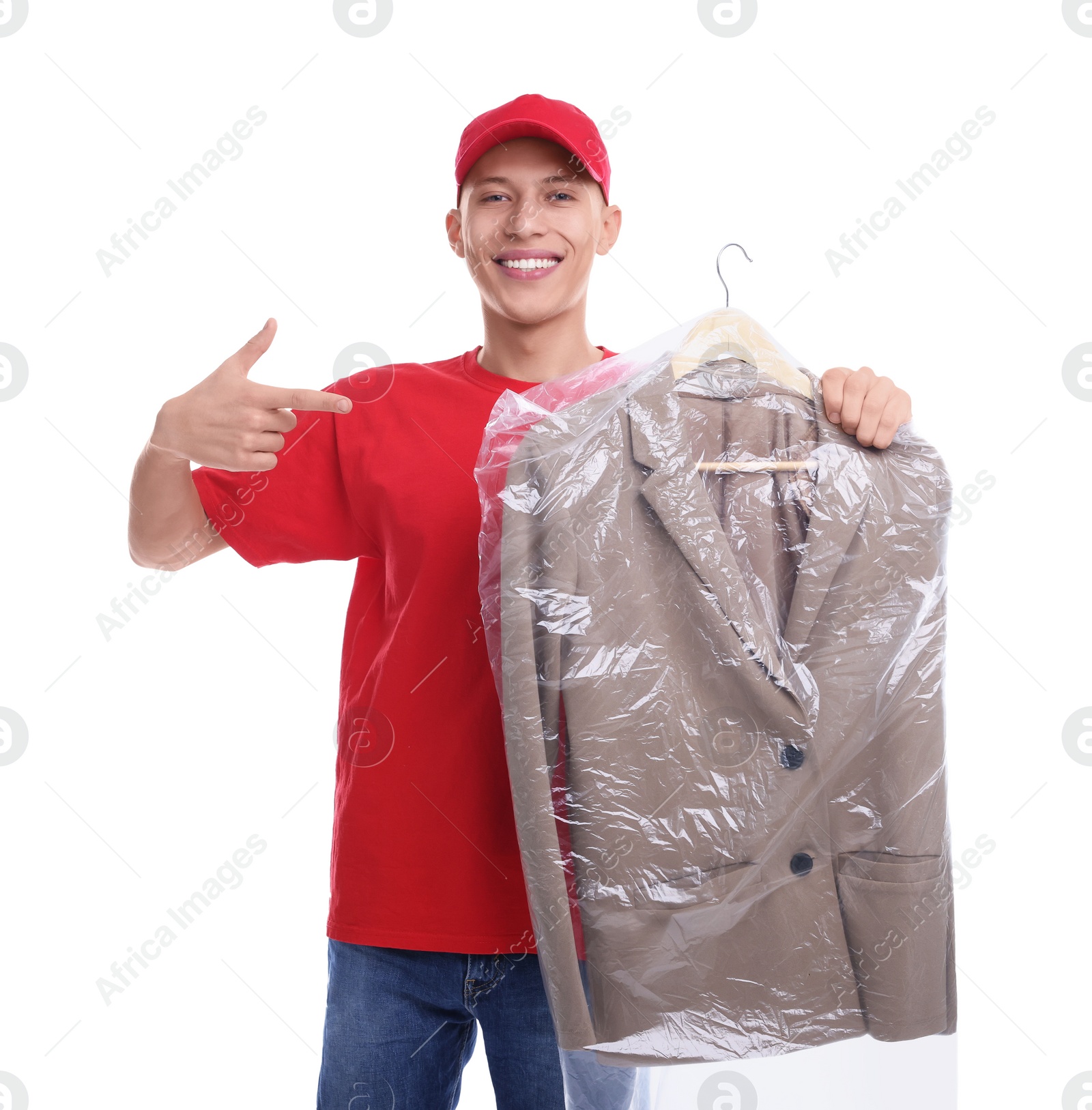 Photo of Dry-cleaning delivery. Happy courier holding jacket in plastic bag on white background