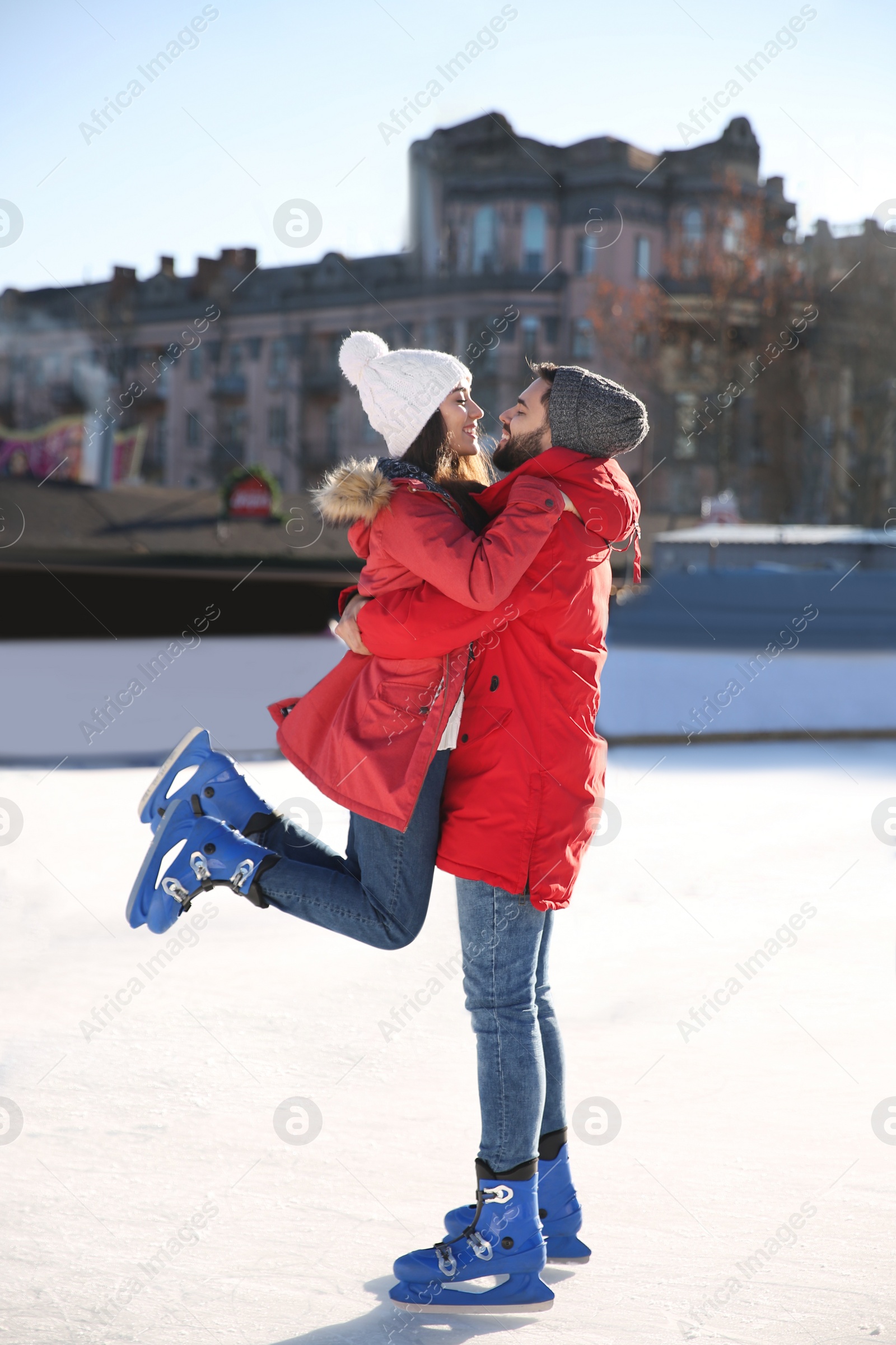 Image of Lovely couple spending time together at outdoor ice skating rink