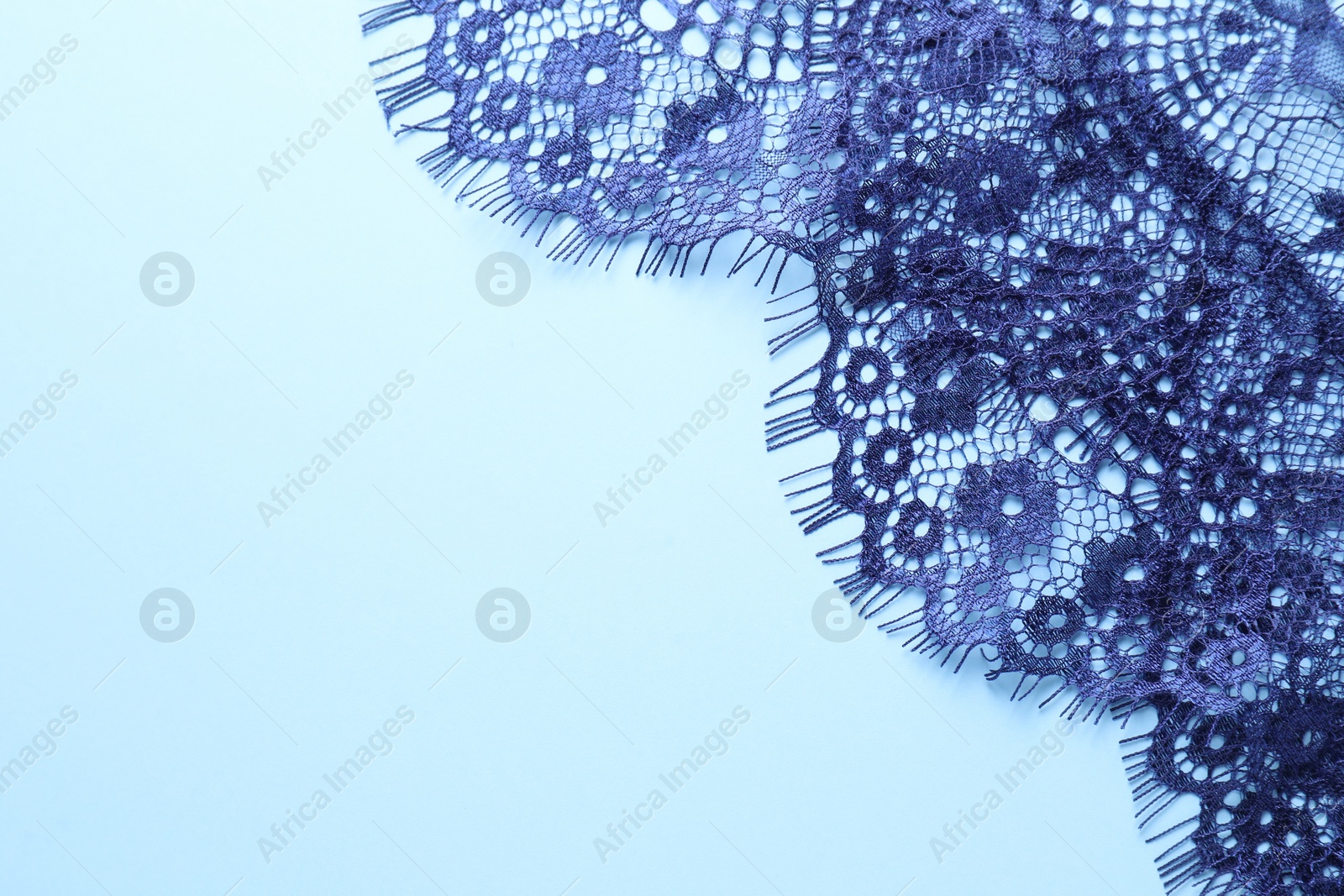 Photo of Beautiful lace on light blue background, top view. Space for text