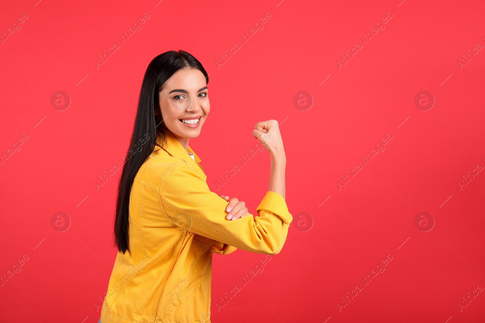 Photo of Strong woman as symbol of girl power on red background, space for text. 8 March concept