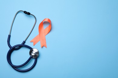 Photo of Orange ribbon and stethoscope on light blue background, flat lay with space for text. Multiple sclerosis awareness