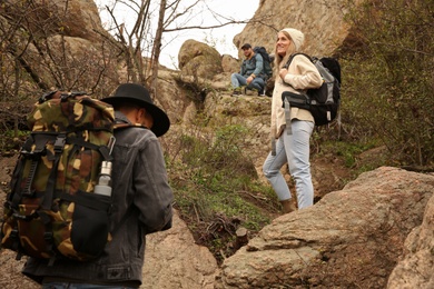 Photo of Group of hikers with backpacks climbing up mountains