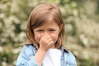 Photo of Little girl suffering from seasonal spring allergy outdoors