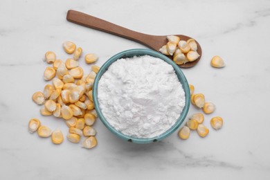 Bowl with corn starch and kernels on white marble table, flat lay