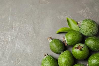 Fresh green feijoa fruits on grey table, flat lay. Space for text