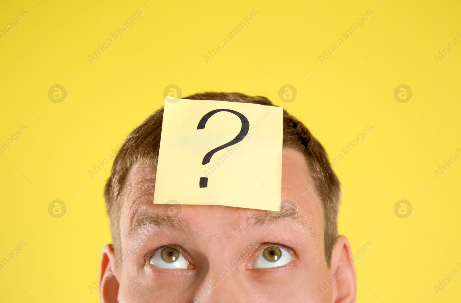 Photo of Emotional man with question mark on yellow  background, closeup