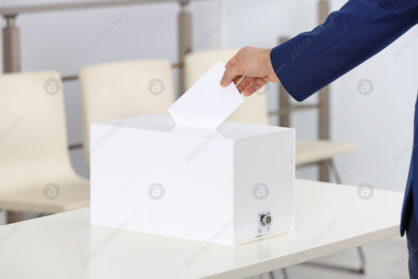 Photo of Man putting his vote into ballot box at polling station, closeup. Space for text