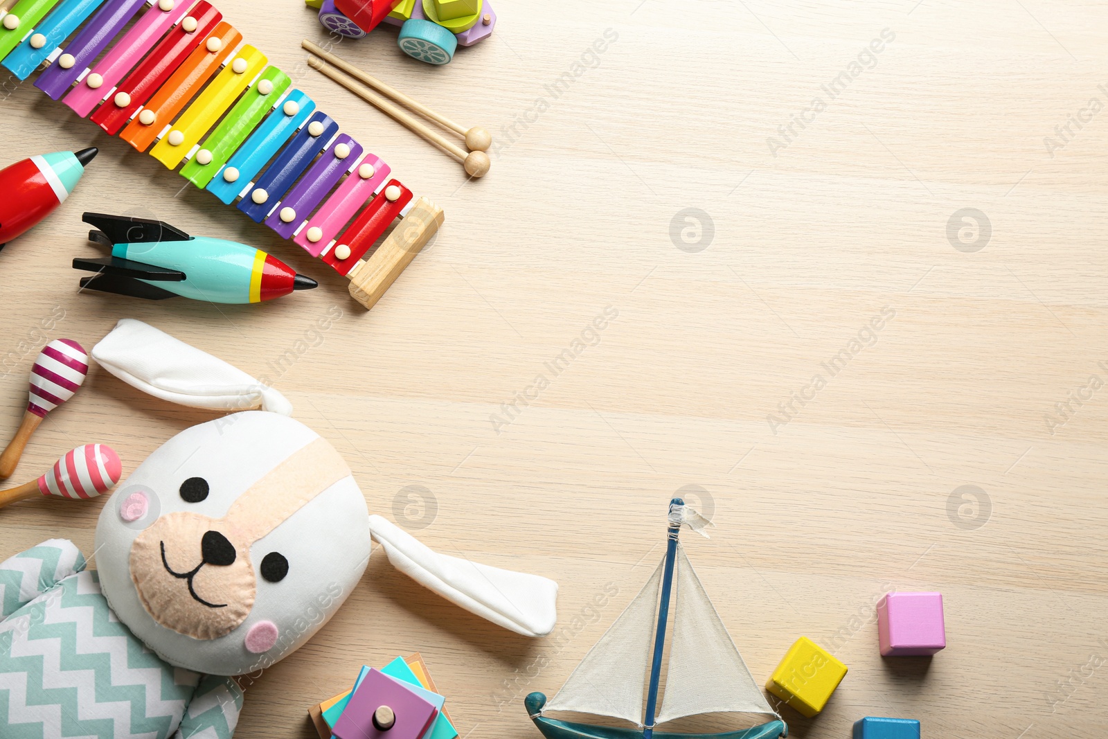 Photo of Different toys on wooden background, flat lay. Space for text