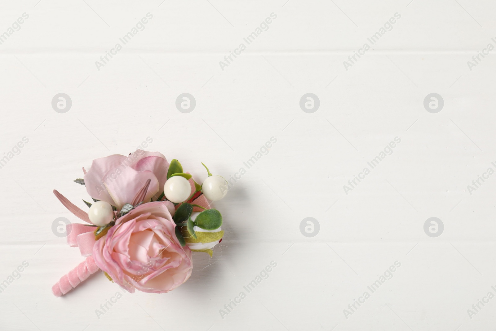 Photo of Beautiful boutonniere on white background, top view. Space for text