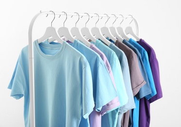 Photo of Men's clothes hanging on wardrobe rack against white background