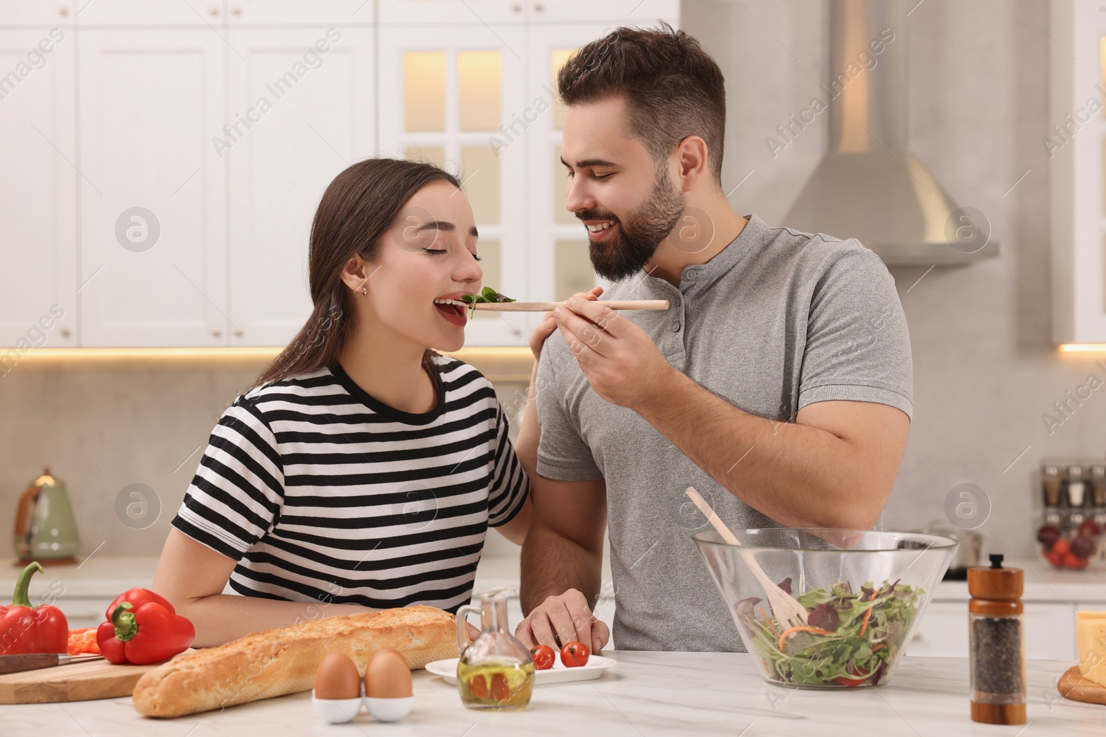 Photo of Lovely young couple cooking together in kitchen