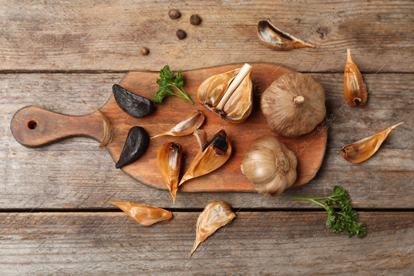 Photo of Flat lay composition with black garlic on wooden table