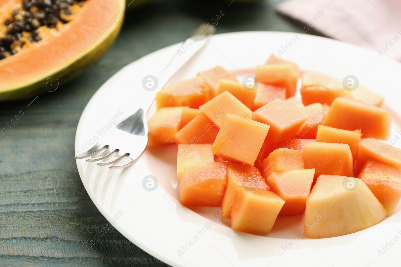 Photo of Plate with diced papaya on table, closeup