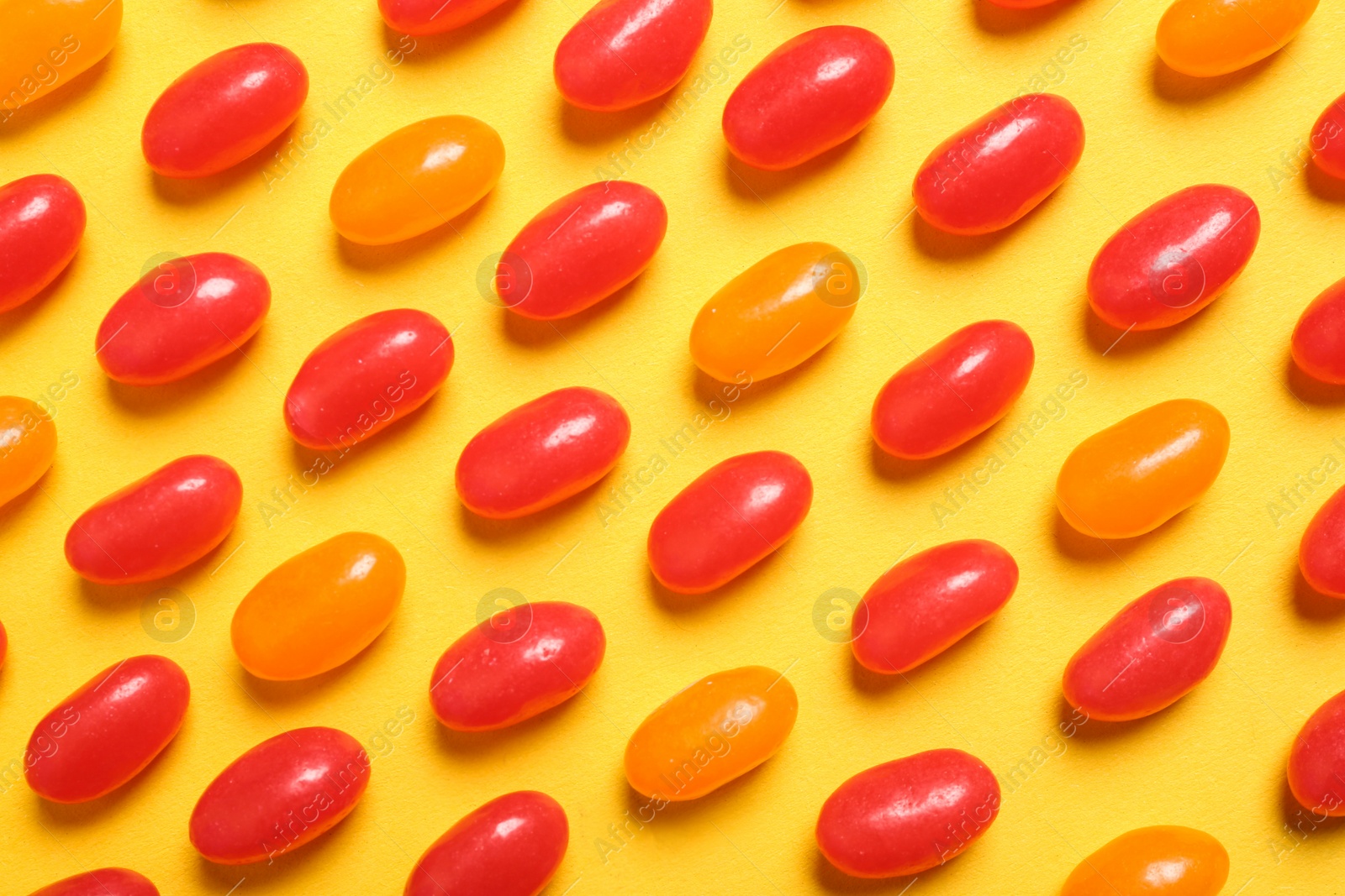 Photo of Flat lay composition with delicious jelly beans on color background