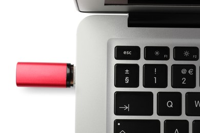 Usb flash drive attached into laptop on white background, top view