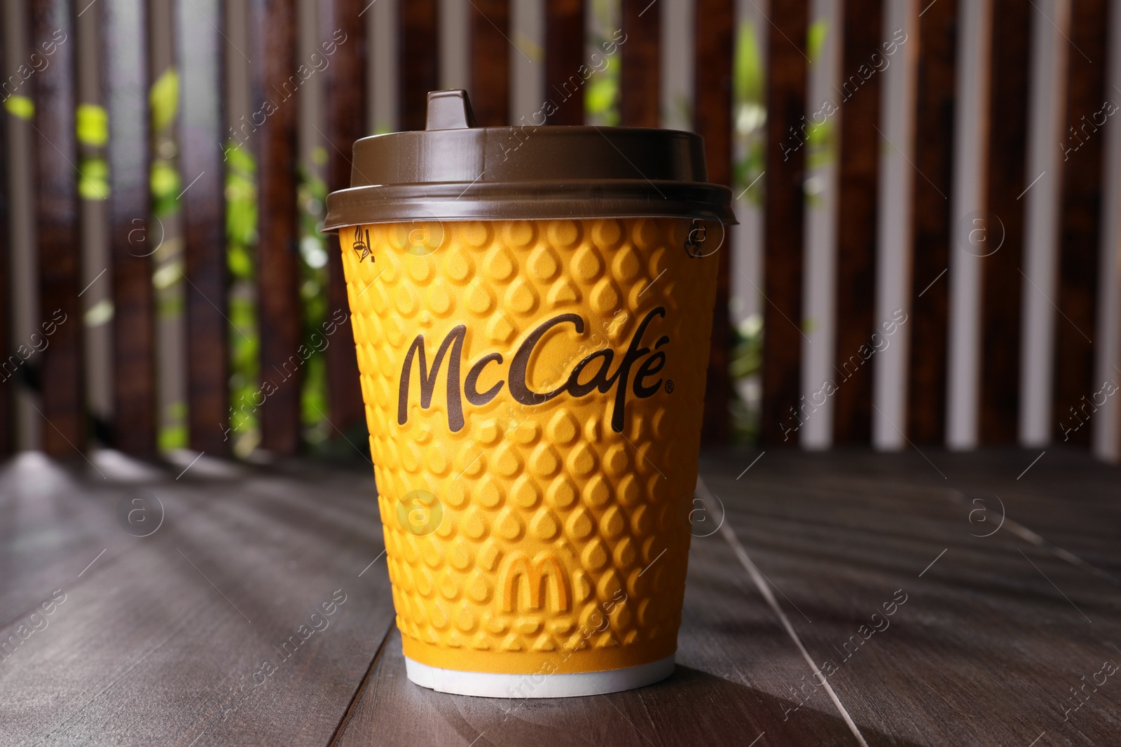 Photo of MYKOLAIV, UKRAINE - AUGUST 12, 2021: Hot McDonald's drink on wooden table