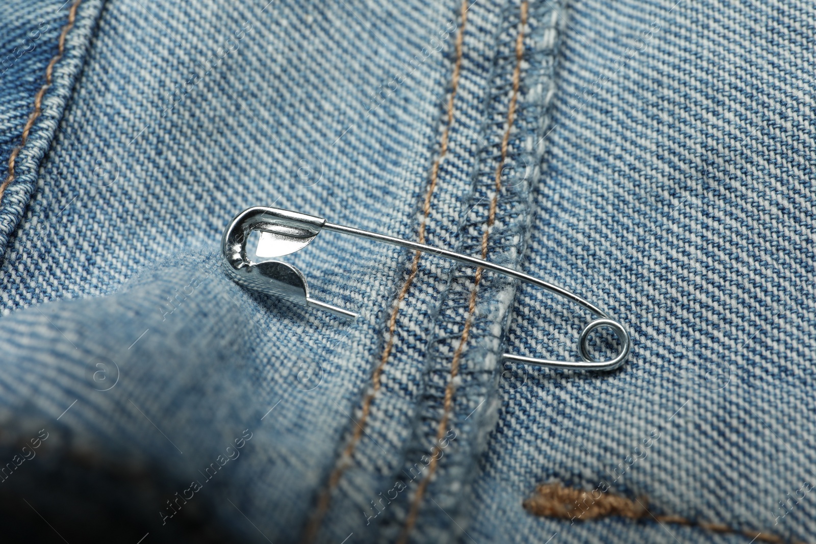 Photo of Closeup view of metal safety pin on clothing