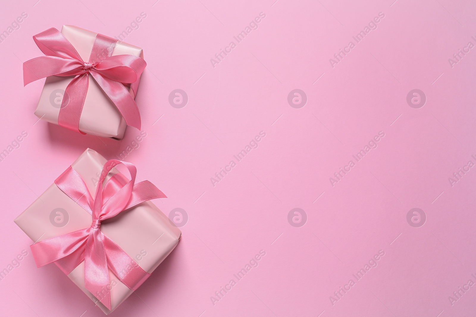 Photo of Beautiful gift boxes on pink background, flat lay. Space for text