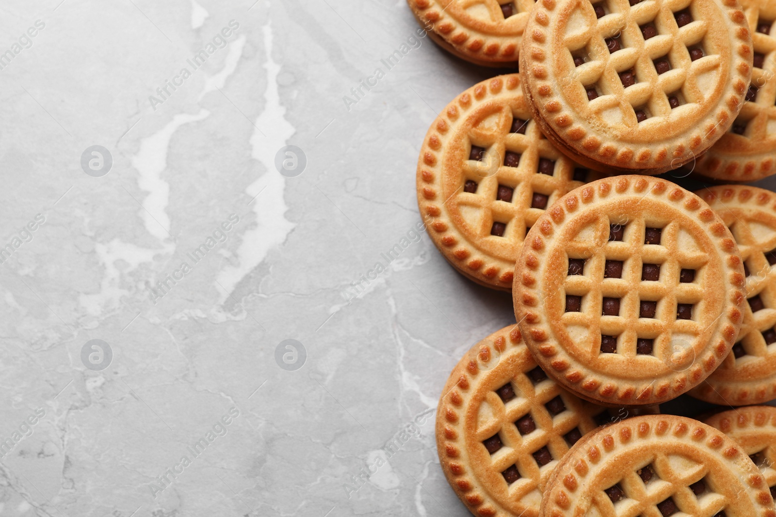 Photo of Tasty sandwich cookies with cream on grey table, flat lay. Space for text