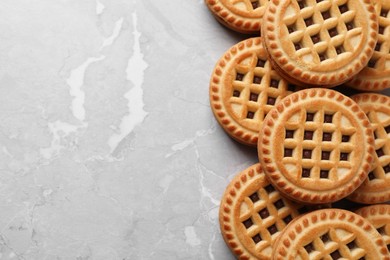 Tasty sandwich cookies with cream on grey table, flat lay. Space for text