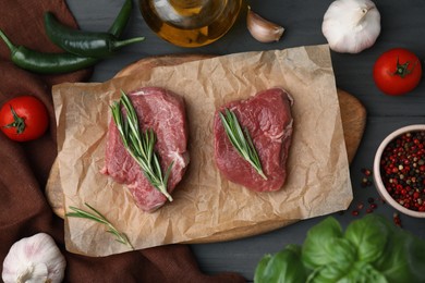 Photo of Flat lay composition with cut fresh beef meat on grey wooden table