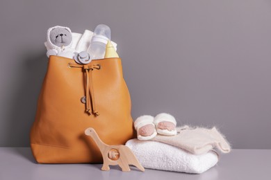Photo of Mother's bag with baby's stuff on gray commode