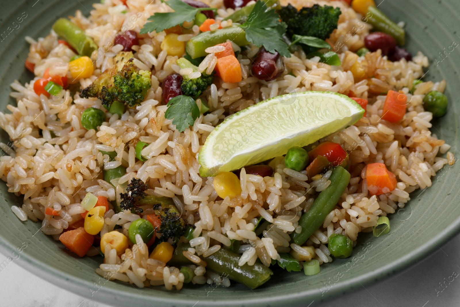 Photo of Tasty fried rice with vegetables in bowl, closeup