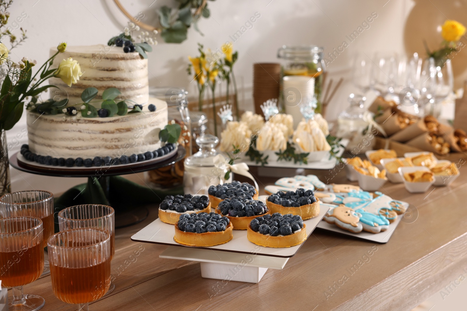 Photo of Beautiful cake and other treats on table in room. Baby shower party